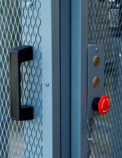 Powder coated grey mezzanine lift with push buttons with e-stop door and handle