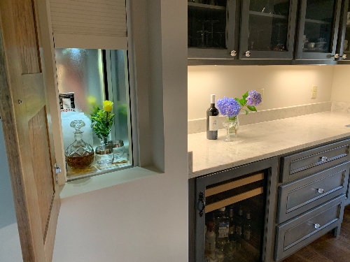 A residential dumbwaiter with flowers, ice bucket, and whiskey