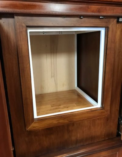 Dumbwaiter tucked into the wooden cabinet (doors open)