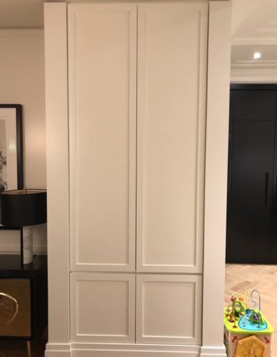 residential dumbwaiter hidden in a home behind white panels